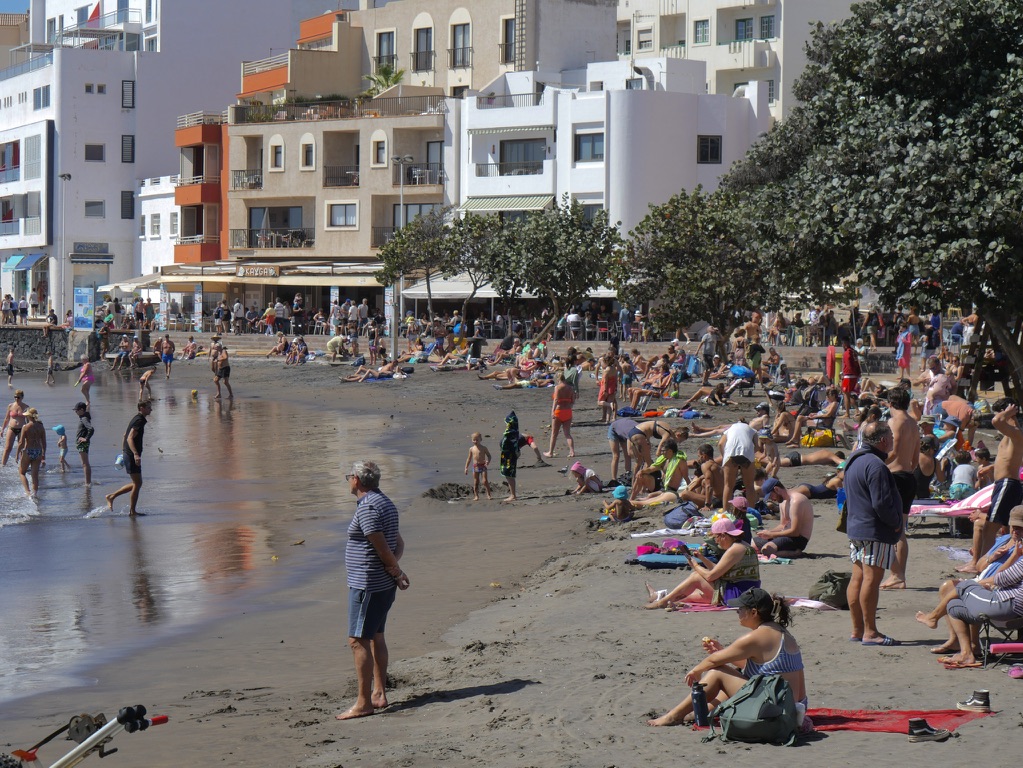 Busy beach and white apartment buildings in the Canary Islands photographed by Oskar Olszewski