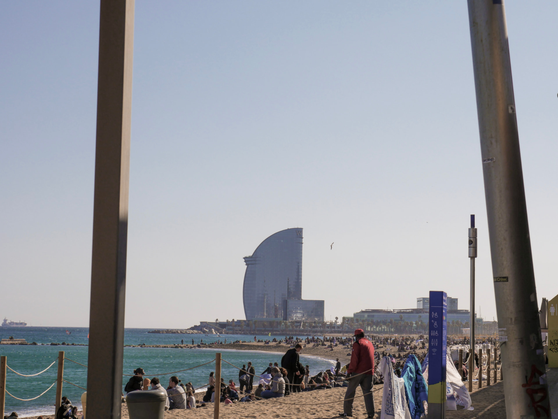Barcelona beachfront framed between two poles photographed by Oskar Olszewski